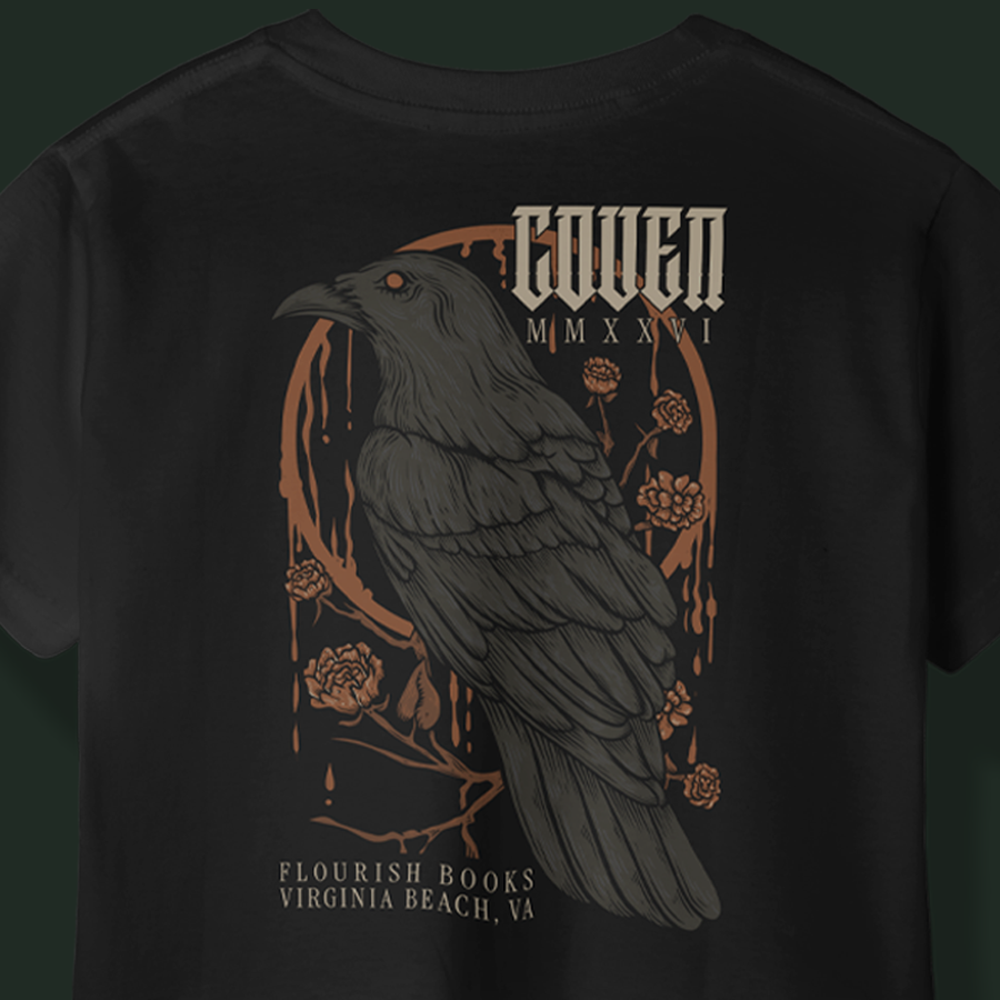 The back of the Coven tee in black: a raven on a thorned branch inside a copper arch, COVEN MMXXVI above, Flourish Books Virginia Beach, VA below