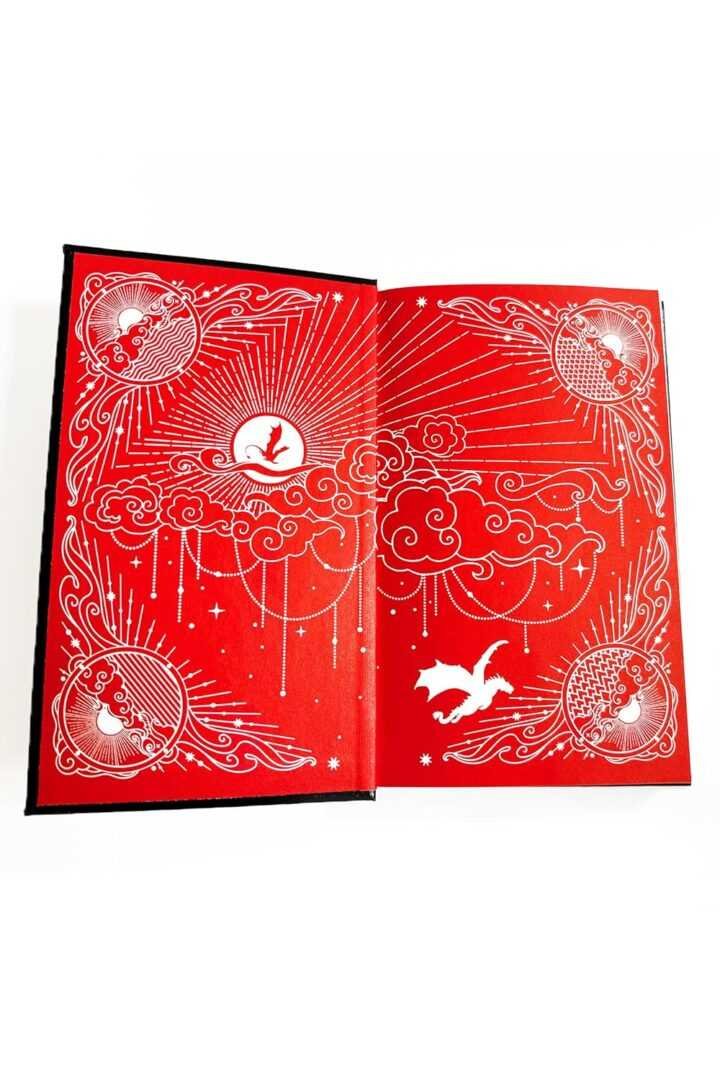 The Official Fourth Wing Journal: Violent Little Thing Edition by Rebecca Yarros features open red pages adorned with detailed white illustrations of clouds, stars, rays, and birds for a mystical celestial effect.