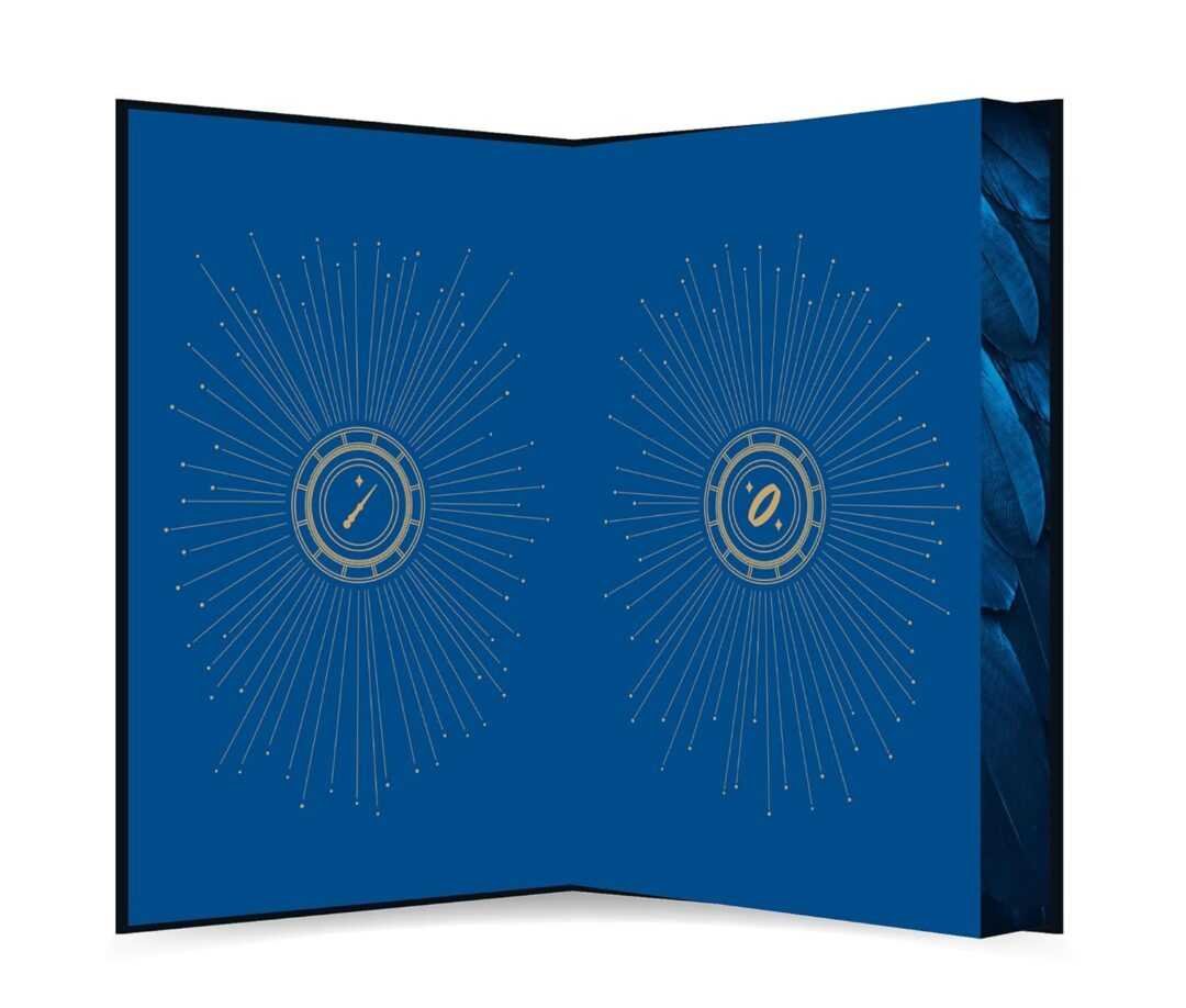 Open blue book with textured edge features two symmetrical gold sunburst designs, geometric central circles, and radiating lines—an elegant reflection of A Vow in Vengeance by Jaclyn Rodriguez (Immortal Desires).