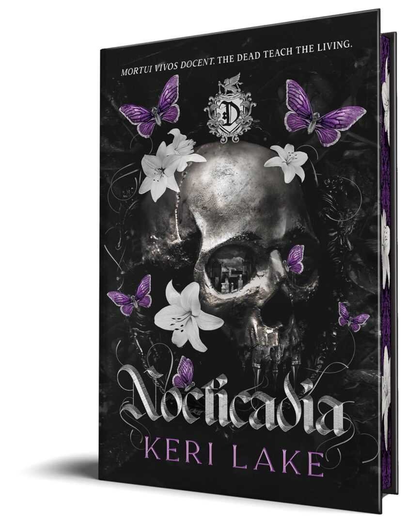 The cover of Nocticadia (Deluxe Edition) by Keri Lake, a romance novel, features a skull amid white lilies and purple butterflies with ornate silver details and the Latin phrase "MORTUI VIVOS DOCENT. THE DEAD TEACH THE LIVING." at the top.