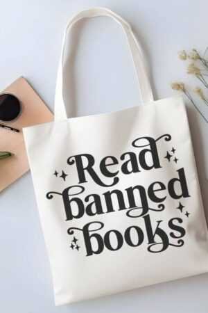 The Read Banned Books Canvas Tote Bag features bold black lettering, floral accents, and space for your essentials—ideal for fans of BookTok trends and contemporary fiction.