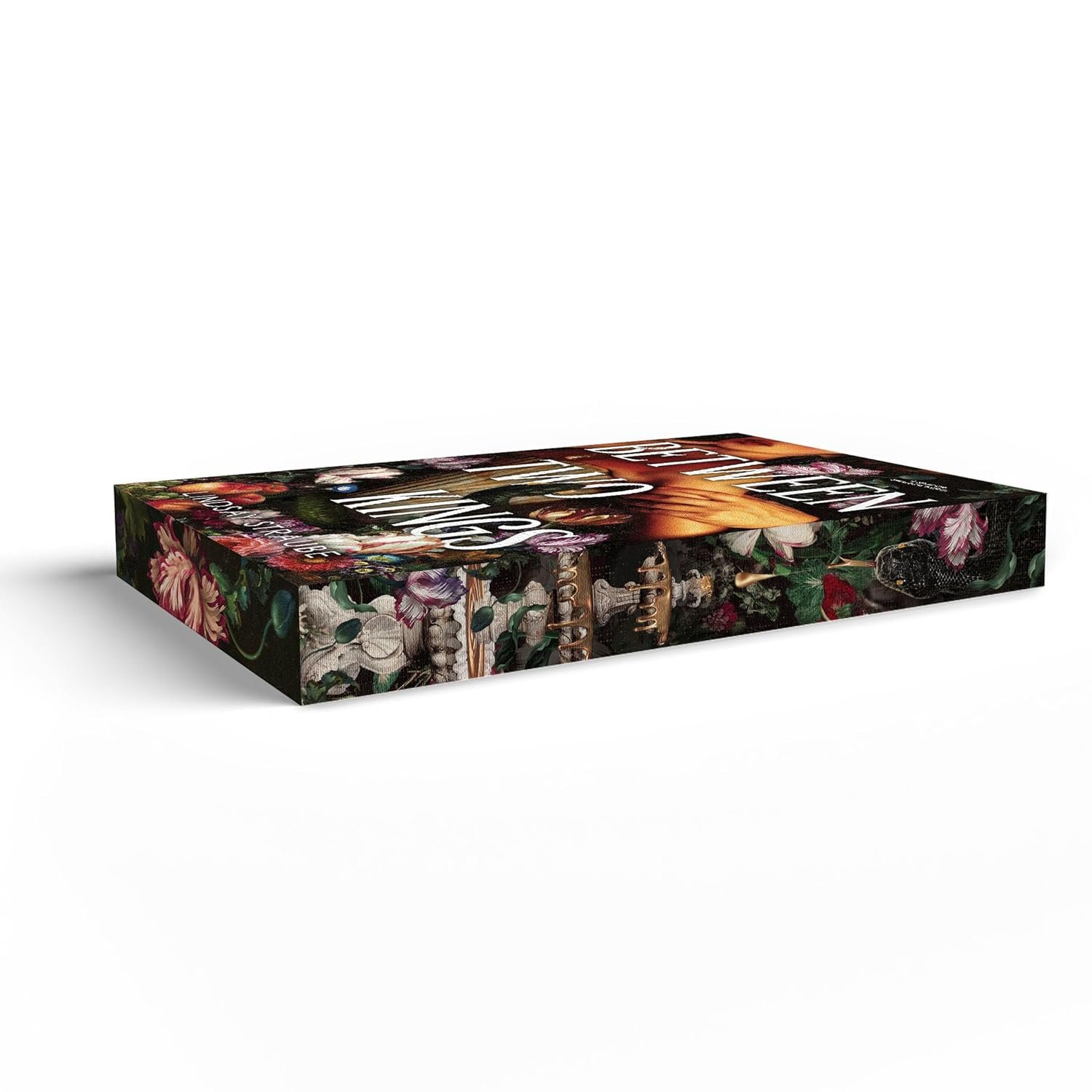 A rectangular box with a floral, nature inspired design features the title Between Two Kings (Deluxe Edition) by Lindsay Straube (Split or Swallow, 2 of 3) in bold white letters on the side, lying flat on a white background.