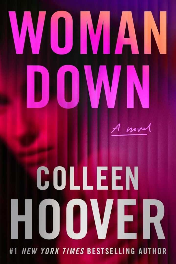 The paperback cover of "Woman Down" by Colleen Hoover features bold pink and white title text over an abstract, blurred woman's face, with the subtitle "A novel." #1 New York Times bestselling author.