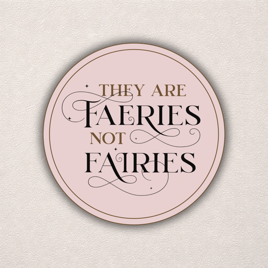 The "Faeries Not Fairies | Sticker" is a round pink sticker featuring elegant black and gold text, star-like accents, and flourishes on a textured light background, reading: “They are faeries not fairies.”.